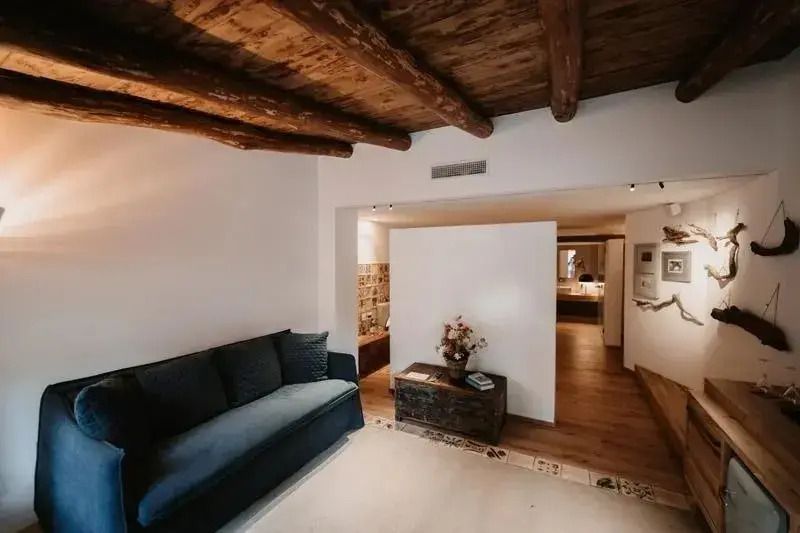 Wohnbereich mit rustikalen Holzbalken und gemütlichem Sofa