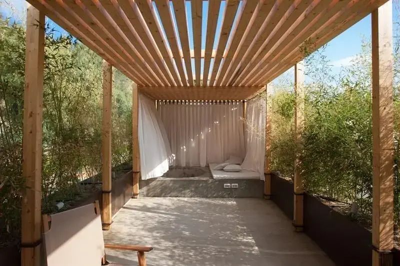 Überdachte Terrasse mit Holzpergola und Bambuspflanzen