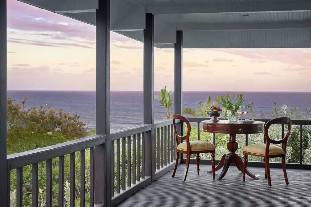 Veranda mit Meerblick und eleganter Sitzgelegenheit bei Sonnenuntergang