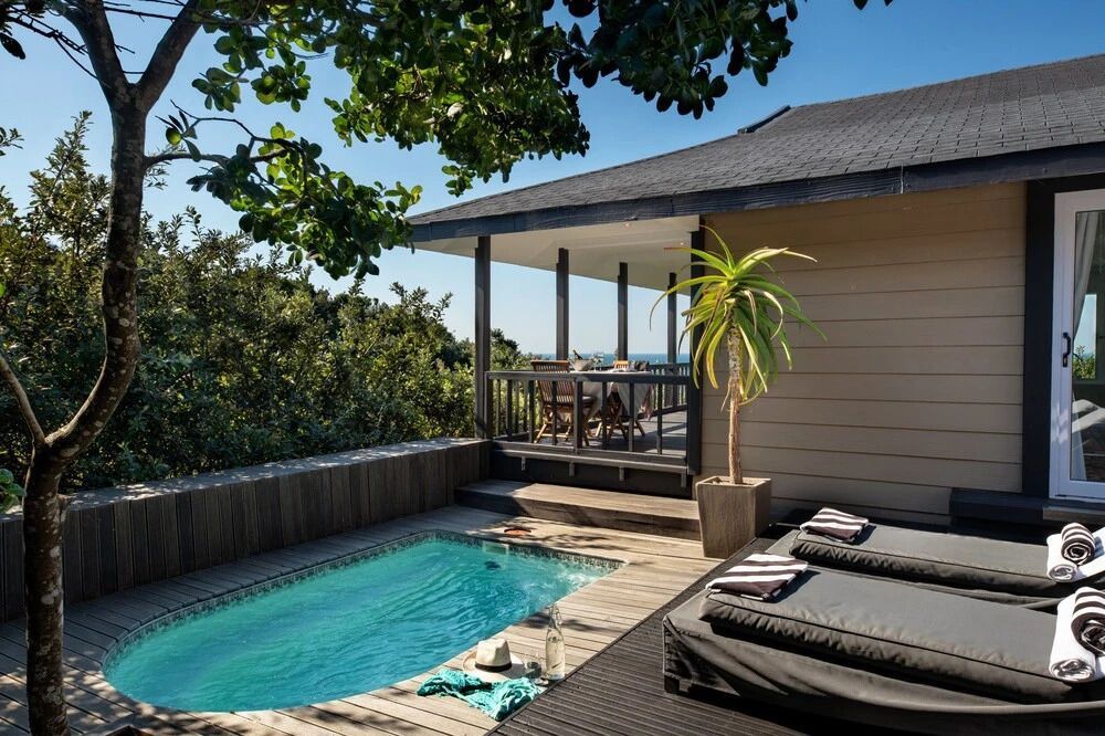 Privater Pool mit Sonnenliegen und tropischer Vegetation