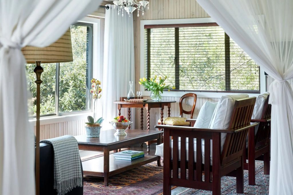 Helle Luxus Suite mit Holzmöbeln und Blick auf den Garten