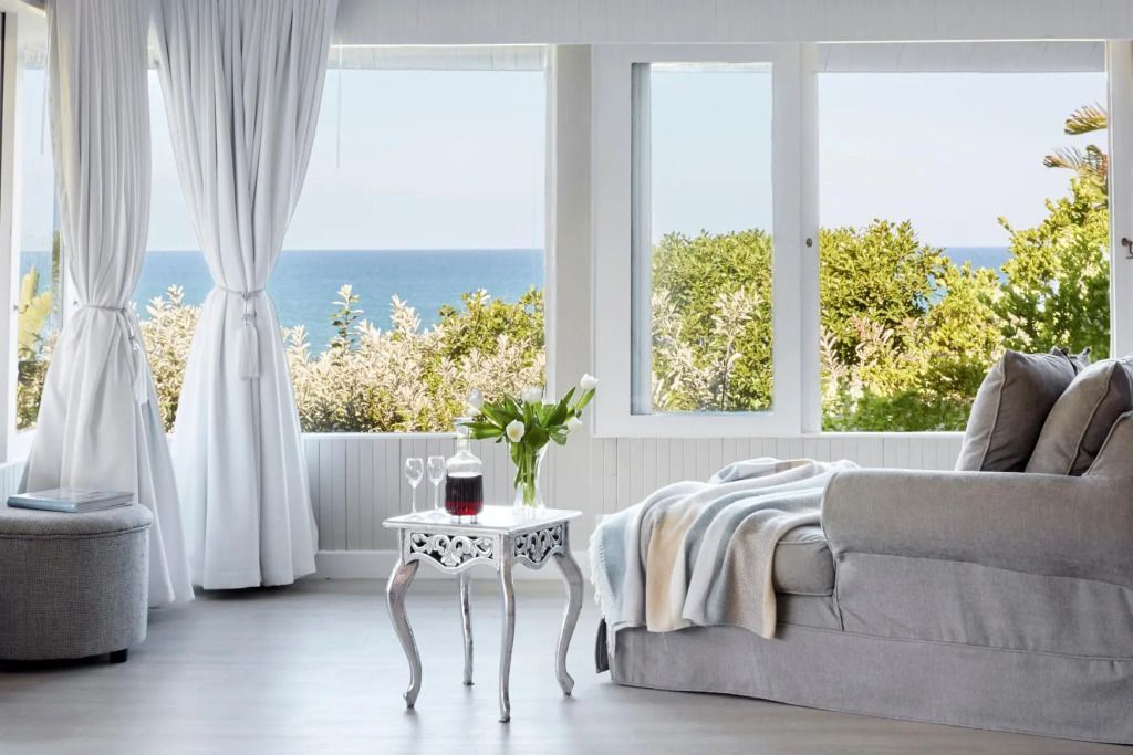 Luxuriöse Suite mit Blick auf das Meer und einen eleganten Tisch mit Blumen