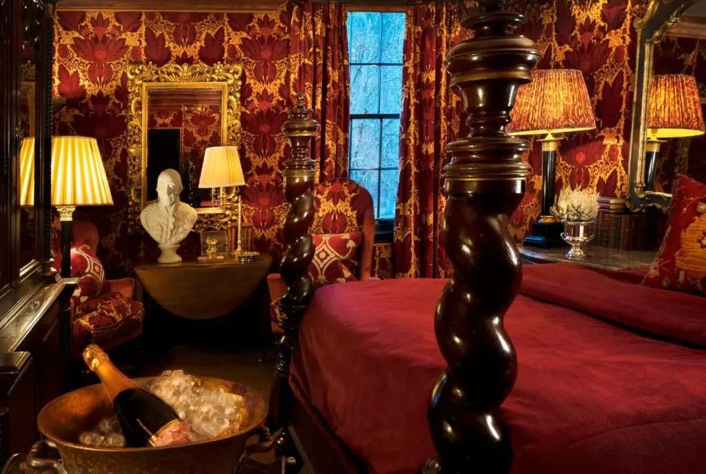 Opulent eingerichtetes Schlafzimmer mit roten Akzenten und Schreibtisch im klassischen Zimmer