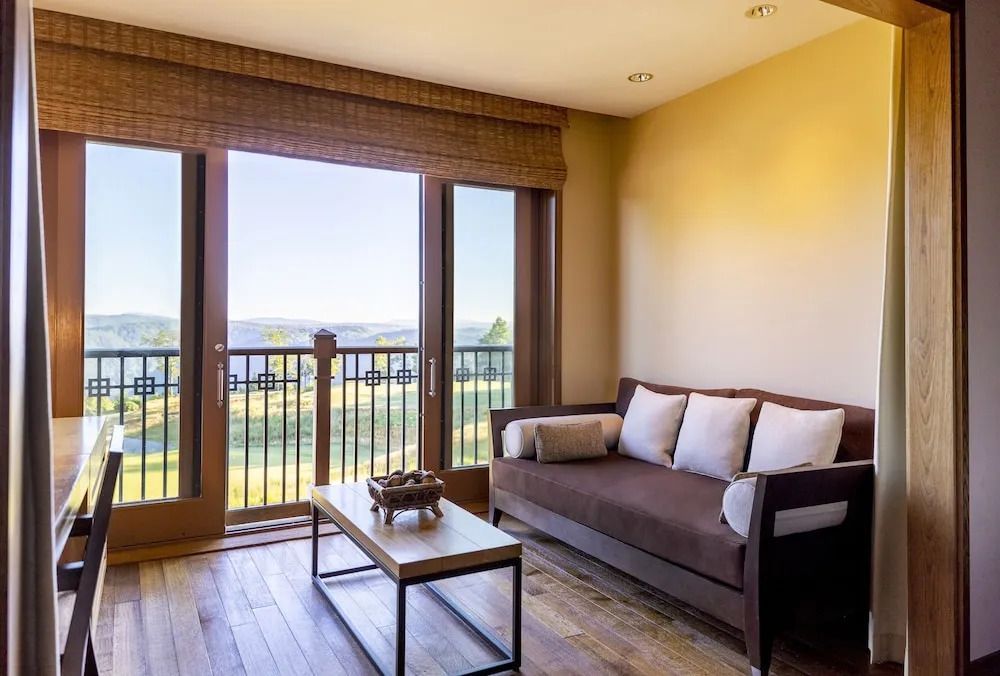 Wohnbereich mit Sofa und Ausblick durch breite Glastüren auf die Landschaft