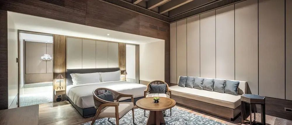 Schlafzimmer mit großem Bett und Sitzgelegenheit in einem gemütlichen Ambiente