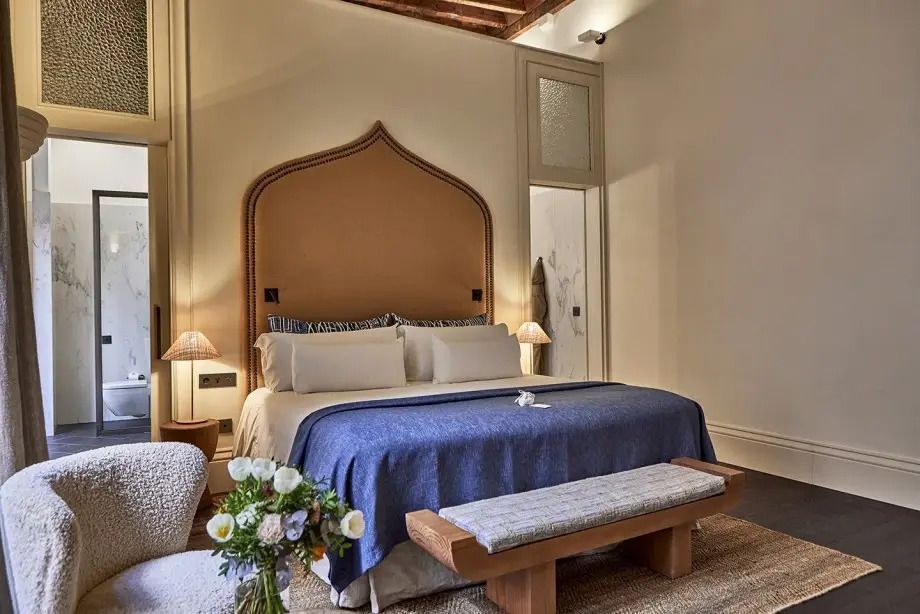 Harmonisches Design der Suite mit Blumenarrangement und luxuriösem Bett.