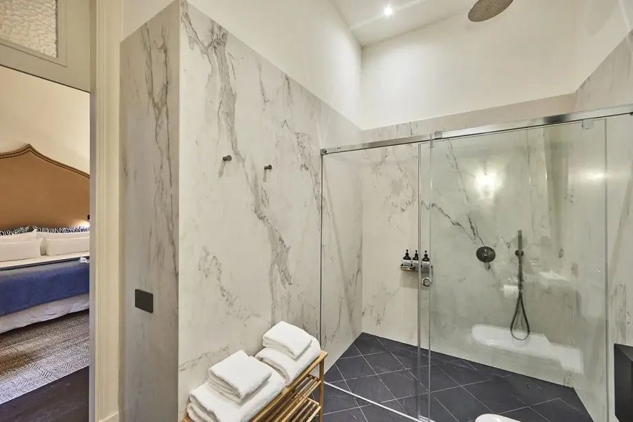 Elegantes Badezimmer im Flow Superior Doppelzimmer mit Marmorwänden und Regendusche