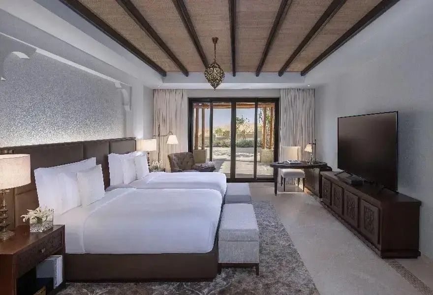 Luxuriöses Schlafzimmer mit Doppelbetten, modernem Dekor und Blick auf die Terrasse