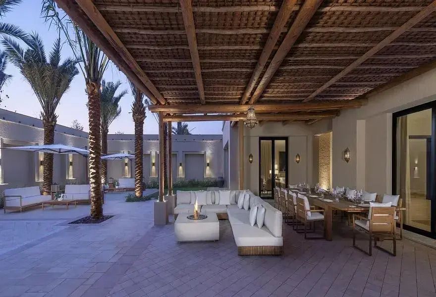 Terrasse mit komfortabler Sitzgelegenheit und Esstisch in elegantem Umfeld