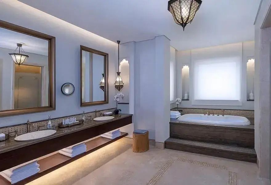 Modernes Badezimmer mit Badewanne, Doppelwaschbecken und dezentem Licht
