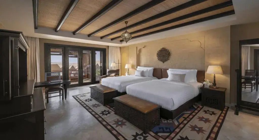 Zimmer mit zwei Einzelbetten und traditionellem Dekor, Holzbalkendecke und Balkon