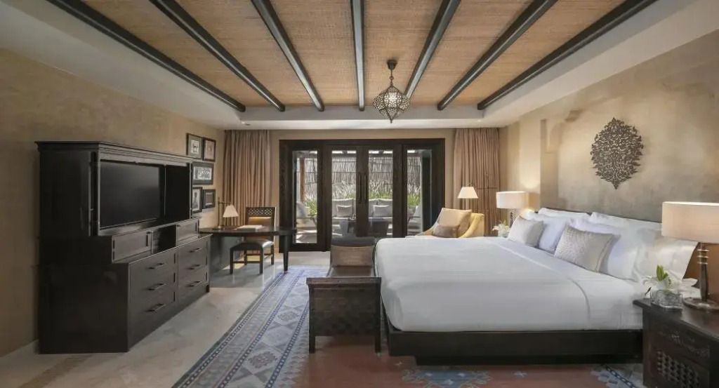 Geräumiges Schlafzimmer mit einem großen Bett, Schreibtisch und Zugang zur Terrasse