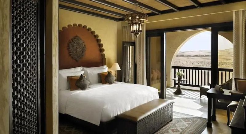 Stilvolles Schlafzimmer mit großem Doppelbett und marokkanischem Dekor im Qasr Al Sarab Resort