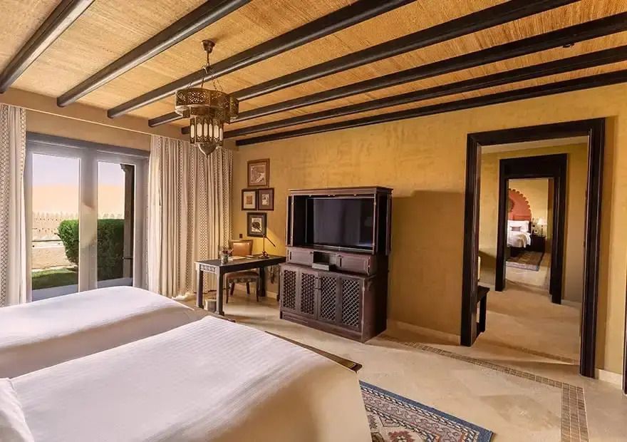 Geräumiges Wohnzimmer der Familiensuite mit traditionellem Dekor und Aussicht auf die Wüste