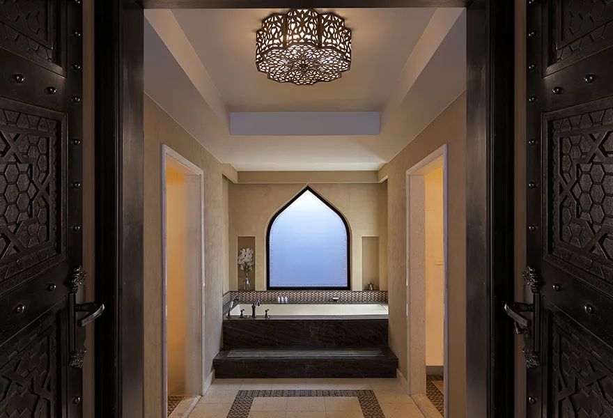 Luxuriöses Badezimmer mit kunstvollen Details und einer großen Badewanne.