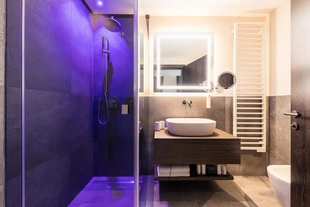 Luxuriöses Badezimmer mit moderner Beleuchtung und großer Duschkabine.