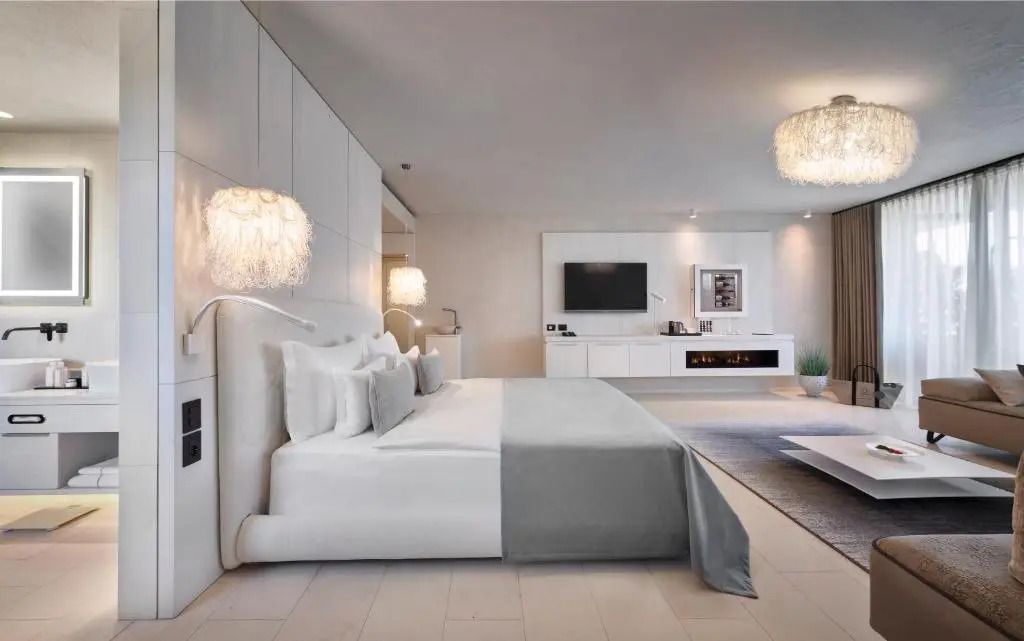 Helles Schlafzimmer mit großem Bett und modernen Leuchten