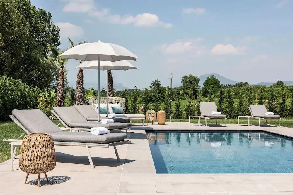 Sonnenliegen und Sonnenschirme am eleganten Außenpool mit Blick auf die Landschaft
