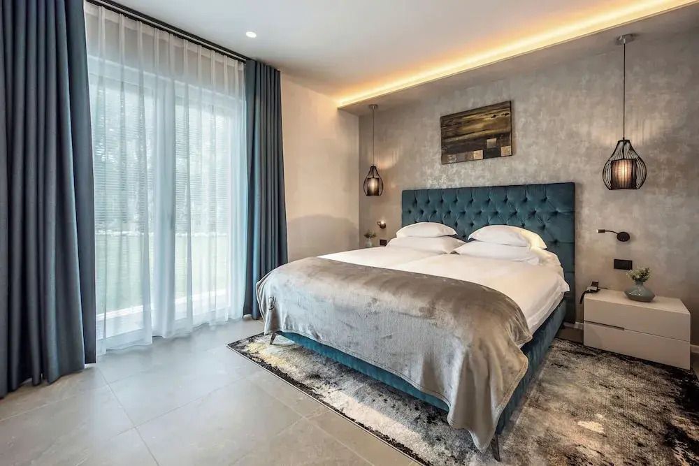 Stilvolles Schlafzimmer mit großem Bett und eleganter Beleuchtung