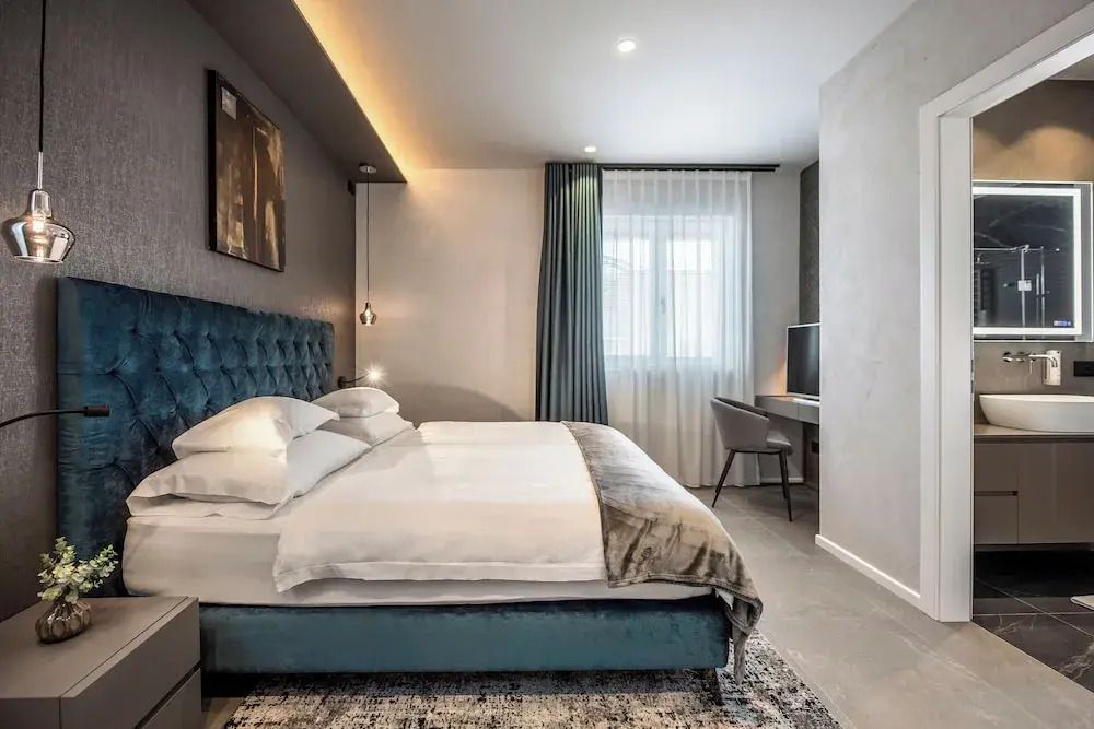 Modern eingerichtetes Schlafzimmer mit Arbeitsbereich und großem Fenster