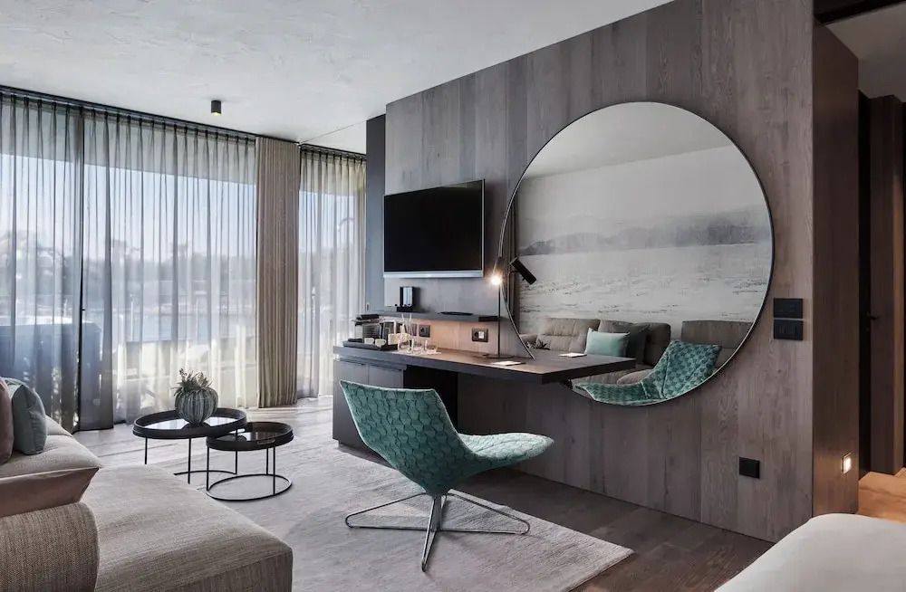 Stilvoller Wohnbereich mit großem Spiegel und Sessel in einer Suite