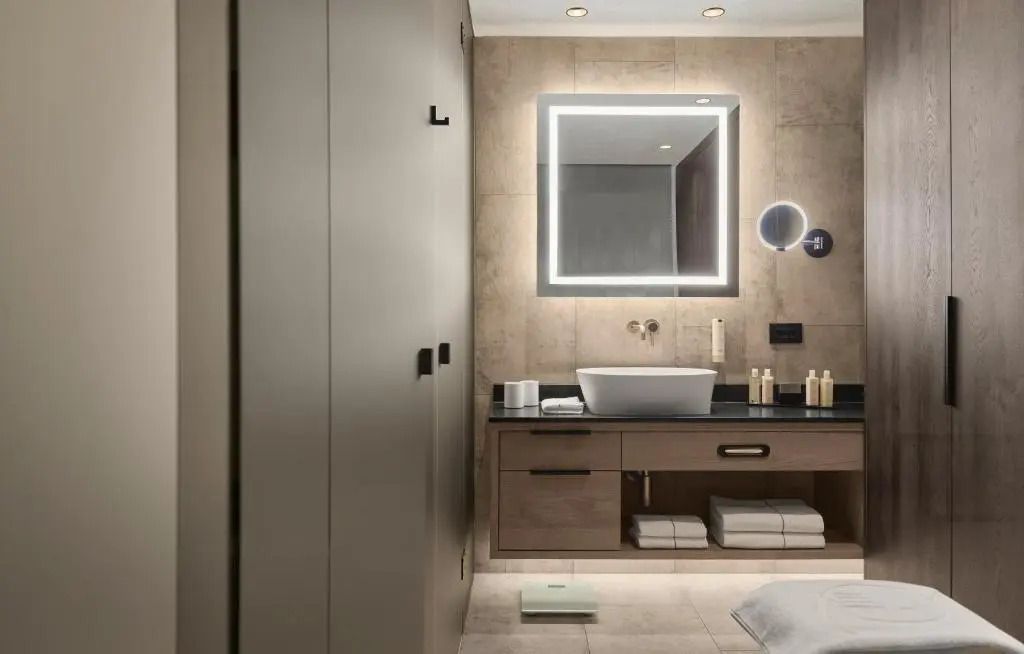 Modernes Badezimmer mit beleuchtetem Spiegel und stilvollen Armaturen in der Junior-Suite.