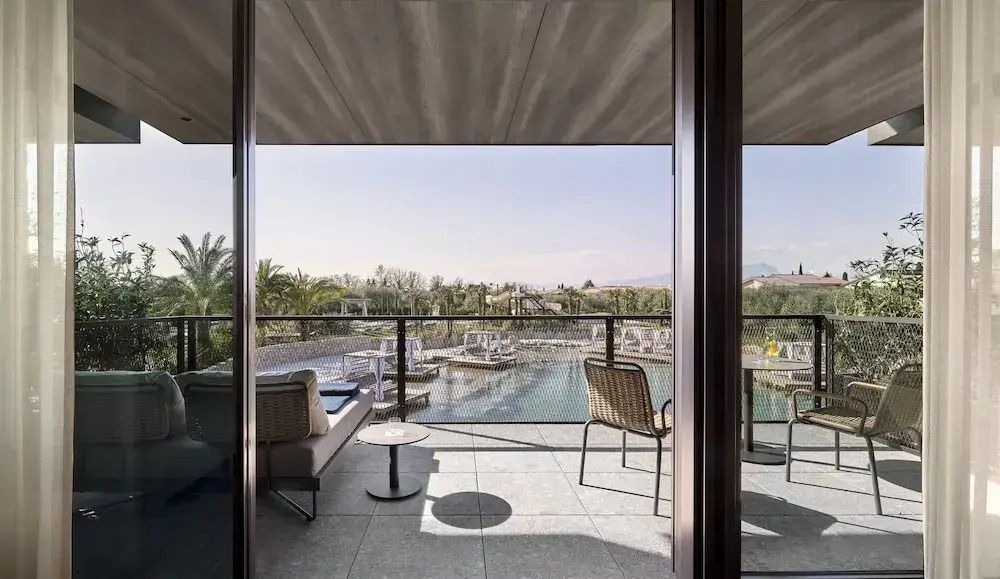 Balkon mit Sitzbereich und Ausblick auf den Garten und Pool