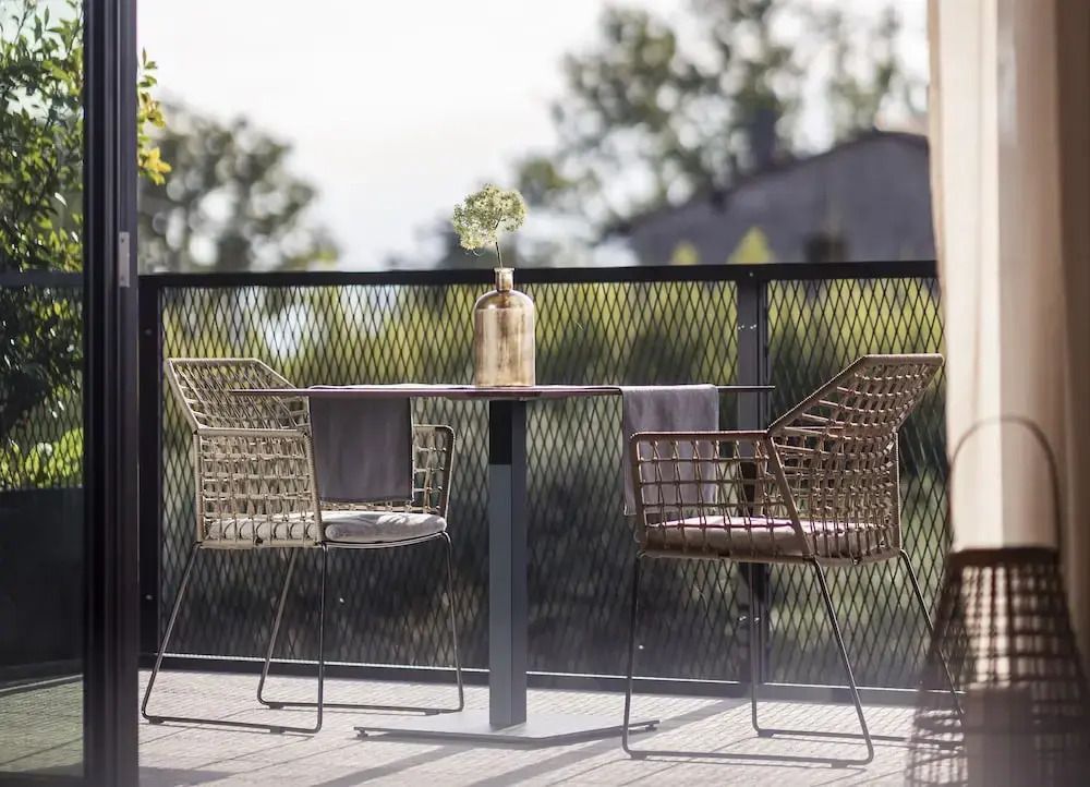 Gemütliche Terrasse mit zwei Stühlen und Tisch im Grünen