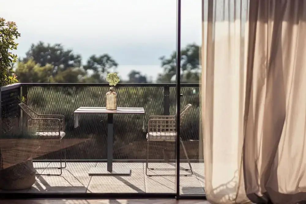 Elegante Terrasse mit Blick ins Grüne durch großes Fenster
