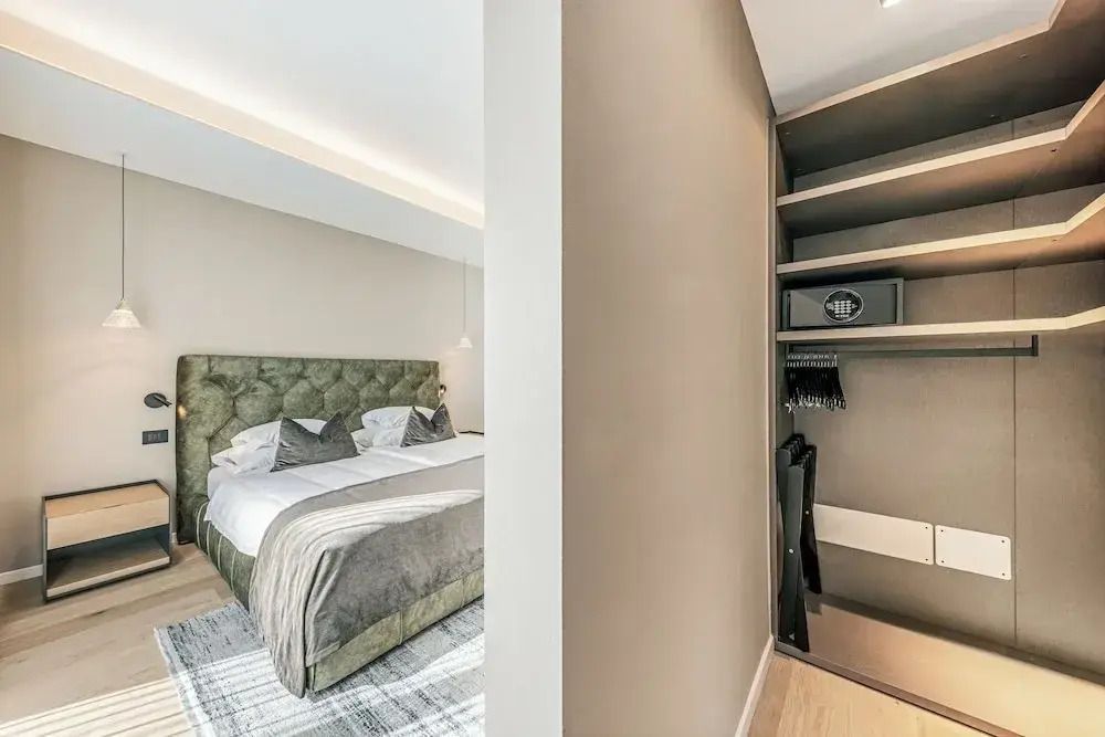 Helles Schlafzimmer mit Doppelbett und offenem Kleiderschrank