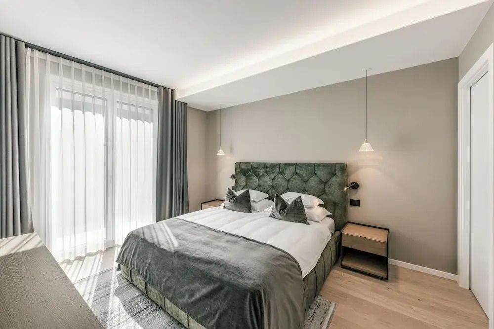 Modernes Schlafzimmer mit grauem Doppelbett und seitlichen Nachttischen