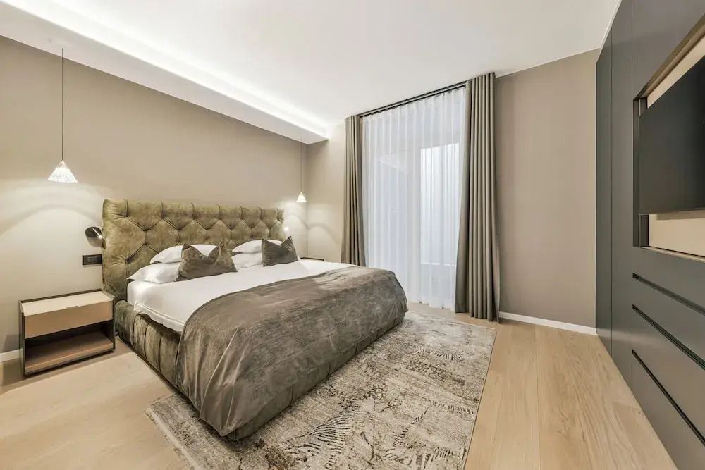 Geräumiges Zimmer mit luxuriösem Doppelbett und großem Teppich