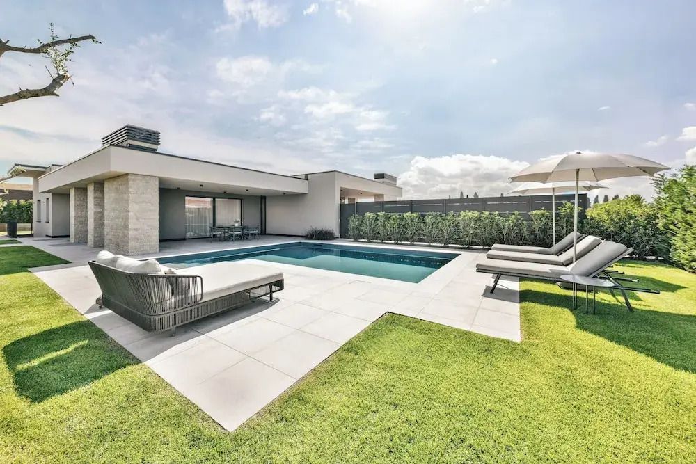 Privater Pool mit Sonnenschirmen und Liegen in moderner Umgebung.