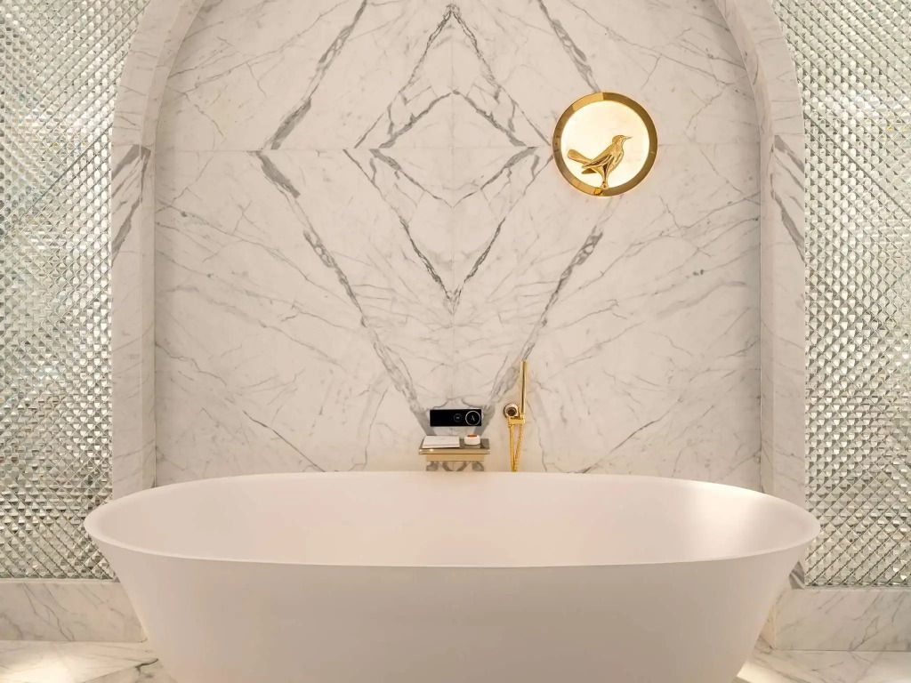 Elegantes Badezimmer mit freistehender Badewanne und goldener Dekoration