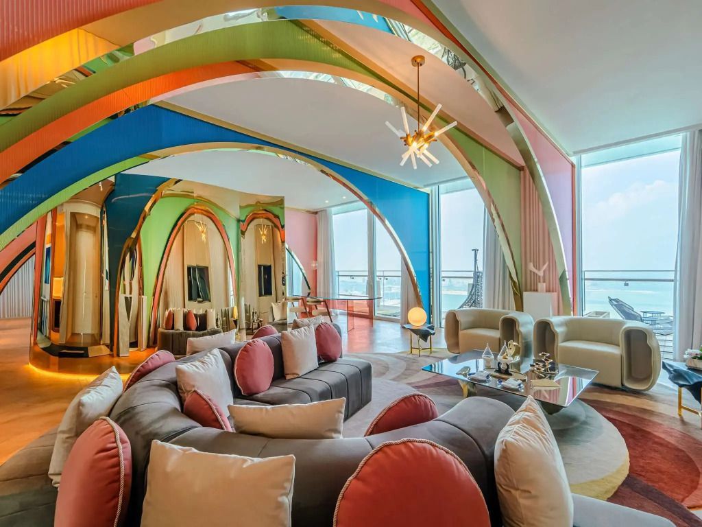 Opulentes Wohnzimmer der Suite mit farbenfroher Einrichtung und Meerblick