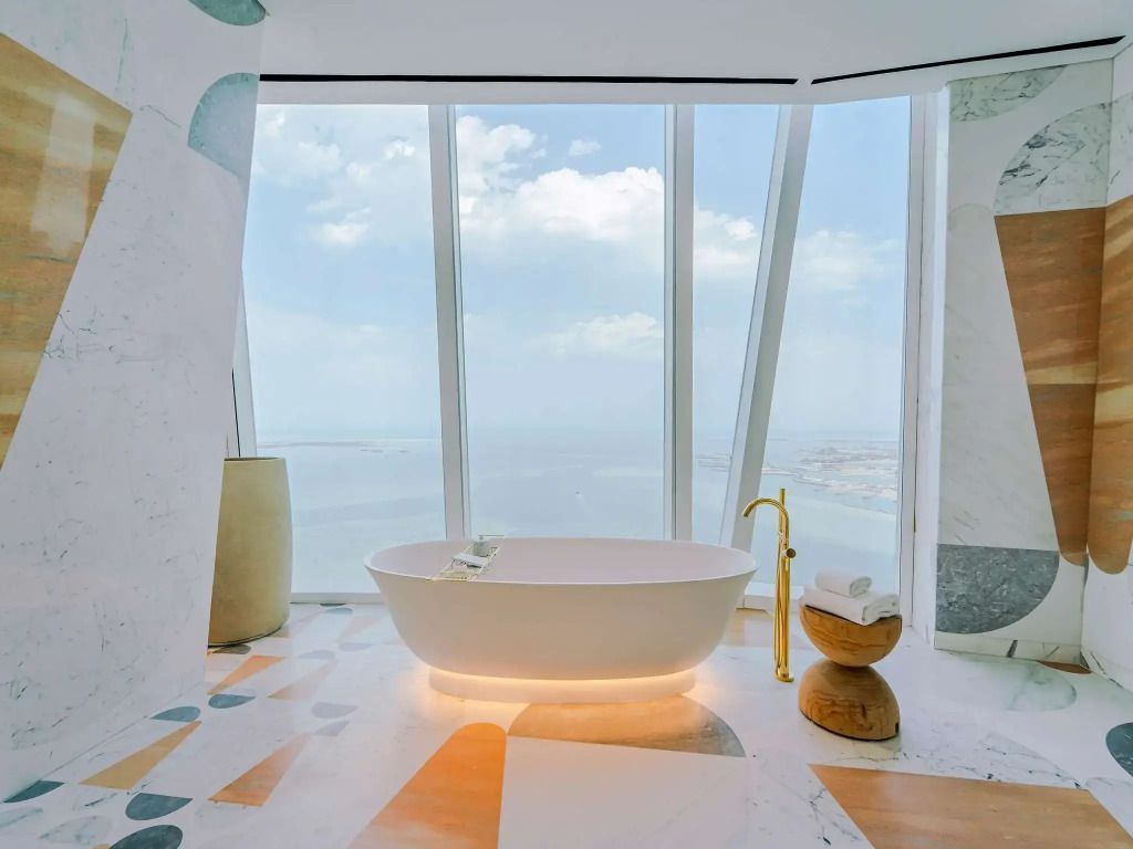 Luxuriöses Badezimmer mit freistehender Badewanne und Panoramablick auf das Meer