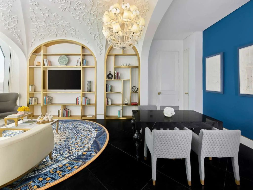 Luxuriöses Wohnzimmer mit eleganter Deckenverzierung und Bücherregalen