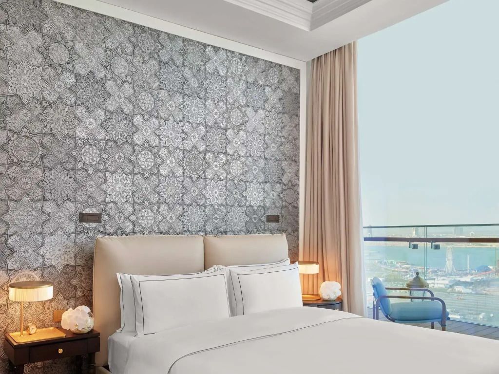 Schlafzimmer mit stilvollem Tapetenmuster und Blick auf den Balkon