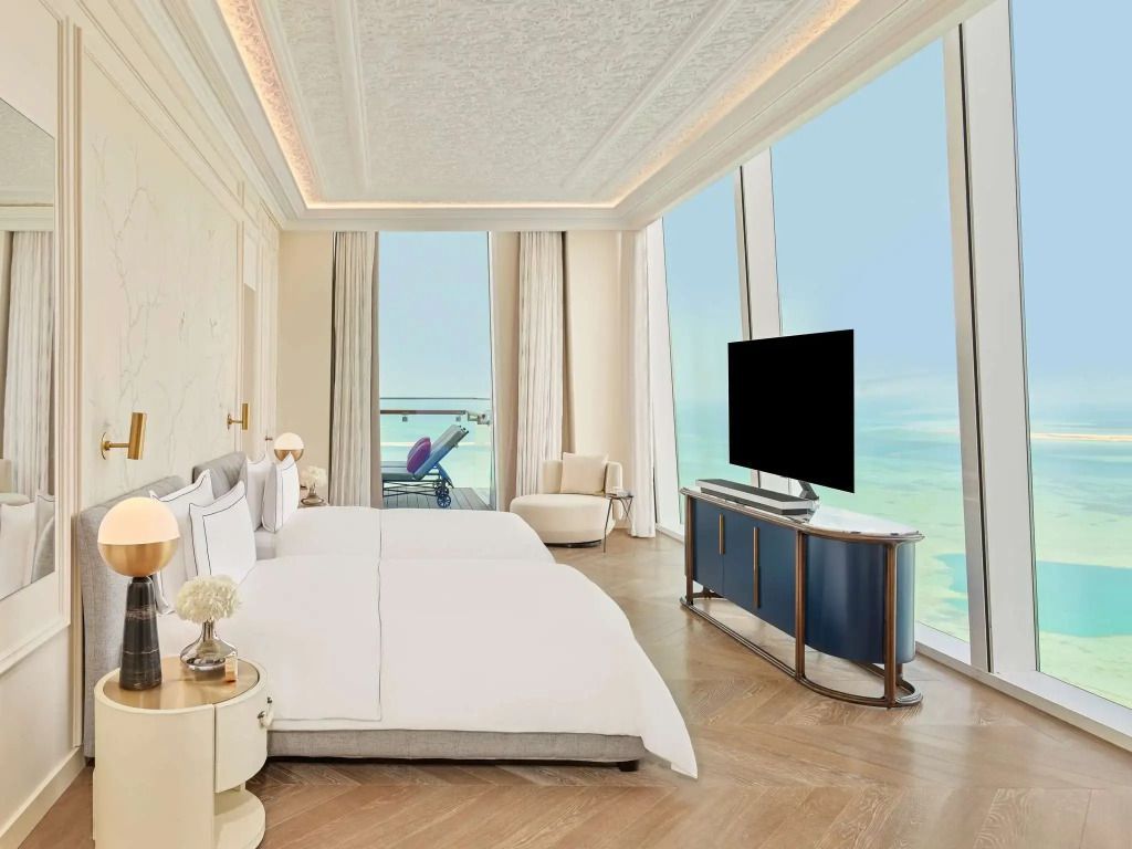 Helles Schlafzimmer mit großen Fenstern und Meerblick in der Parisian Suite des Raffles Doha