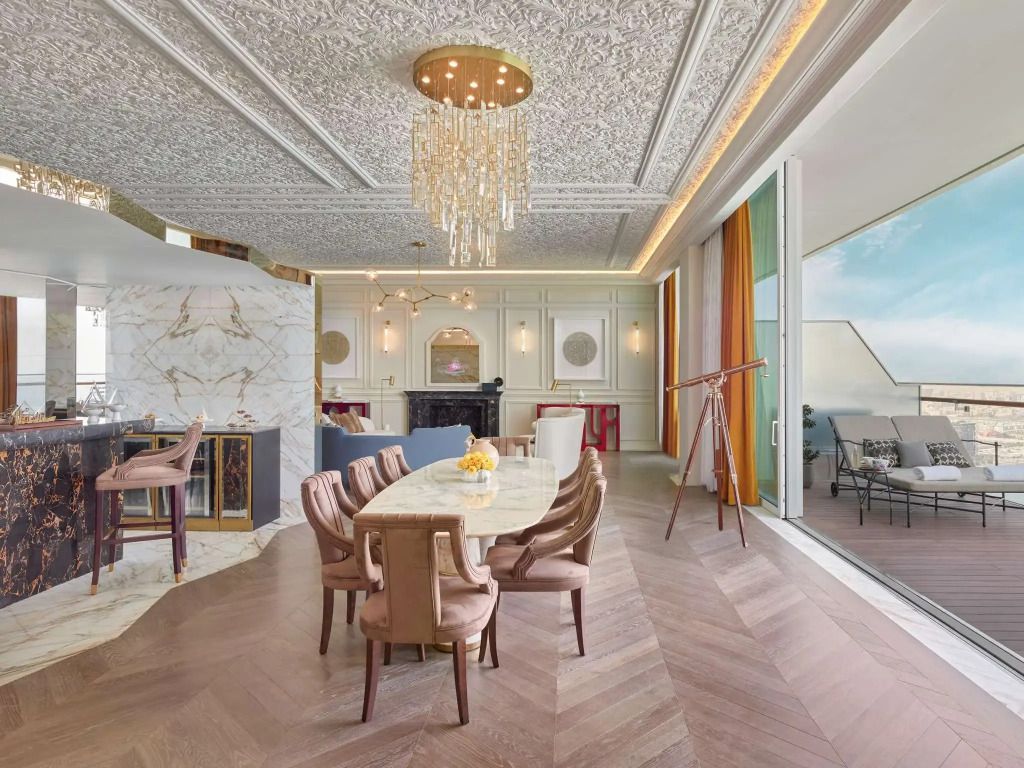 Exquisite Esszimmer mit Kronleuchter und Zugang zum Balkon in der Parisian Suite des Raffles Doha