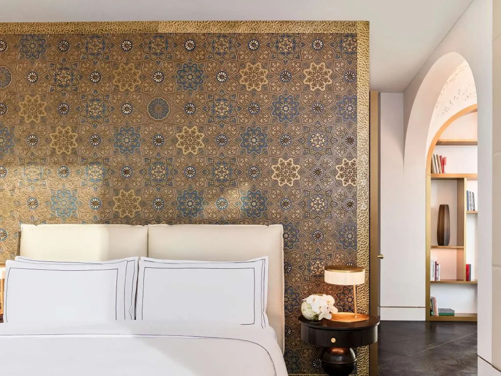 Luxuriöses Doppelbett mit reich verziertem Kopfteil aus Mosaik in der Urban Doppel Signature Suite.