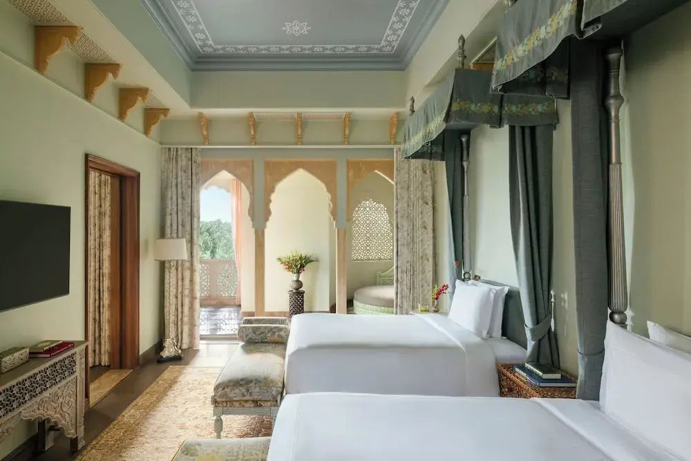 Luxuriöse Schlafzimmer mit zwei Doppelbetten und eleganter Einrichtung im Raffles Jaipur
