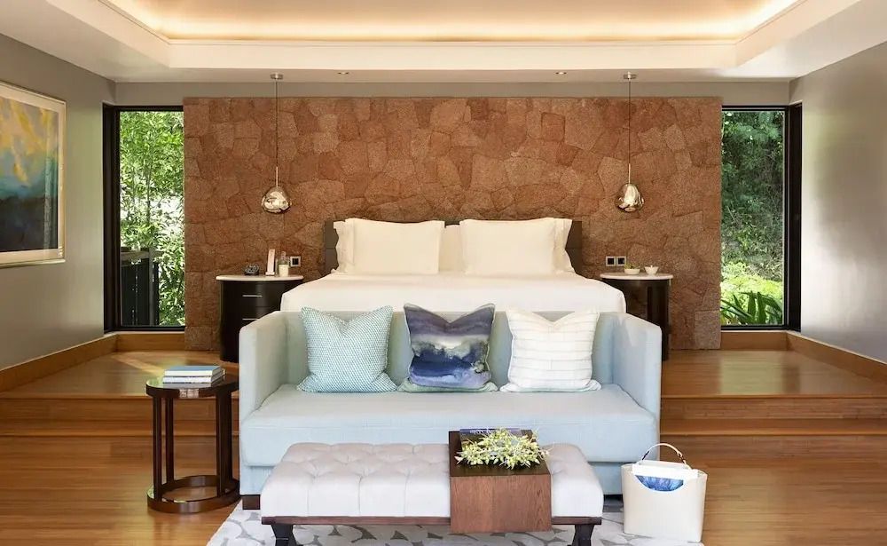 Geräumiges Schlafzimmer mit großer Couch und Steinwand in der Hillside Villa.