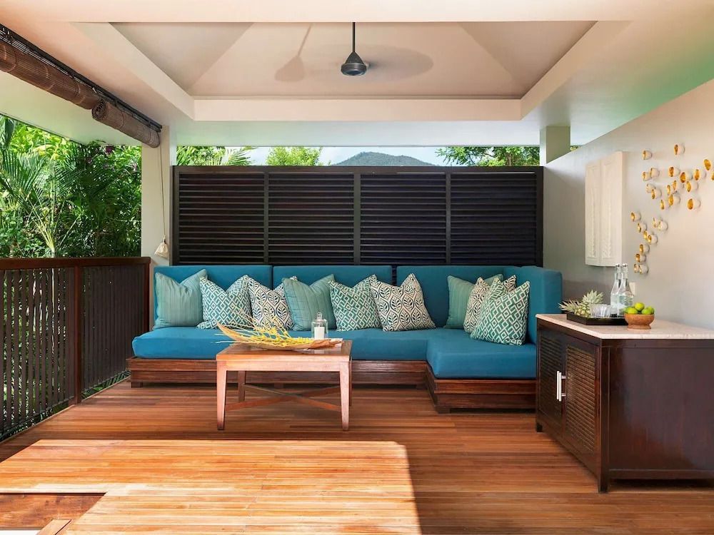Entspannte Terrasse mit blauer Couch und Holzboden in der Hillside Villa.