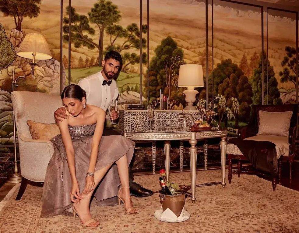 Elegantes Paar in luxuriösem Wohnzimmer. Champagner und Kerzen auf dem Tisch.