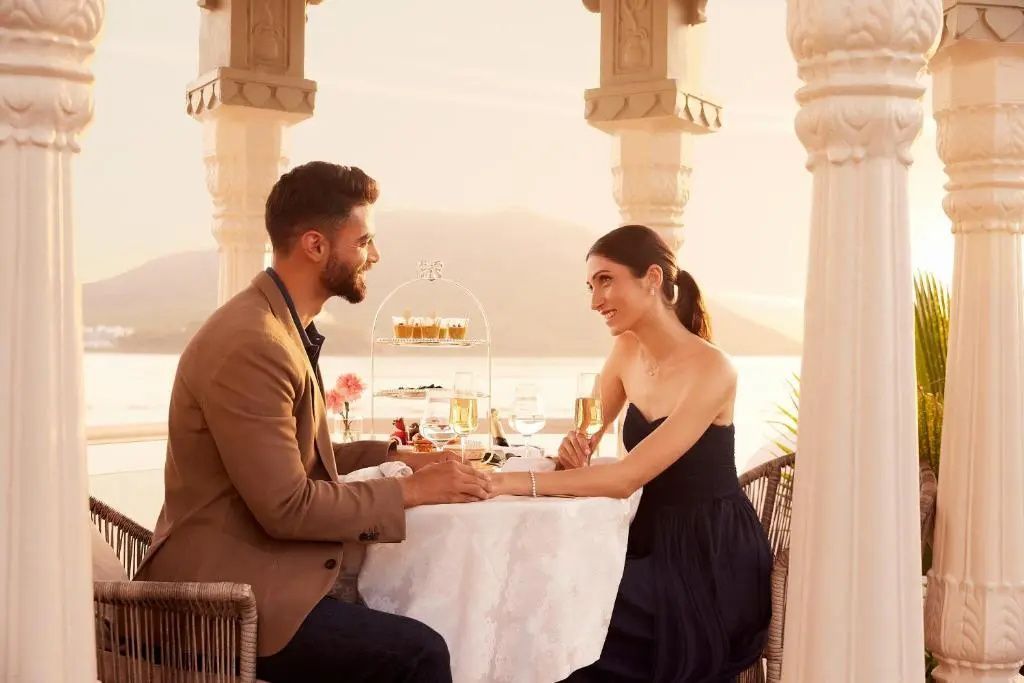 Paar genießt romantisches Abendessen bei Sonnenuntergang im Freien