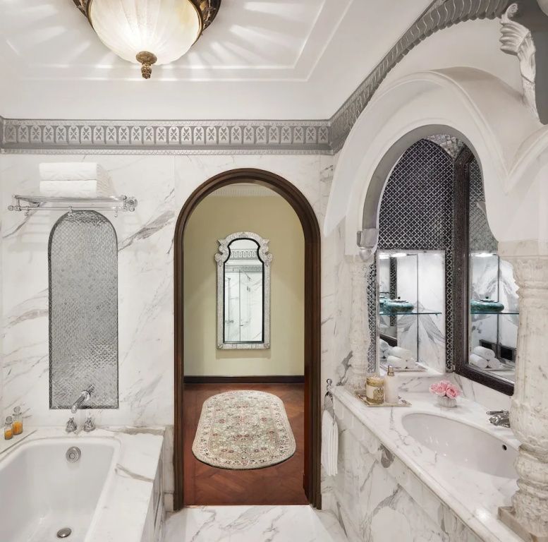 Luxuriöses Badezimmer mit Marmordetails und eleganten Bögen.