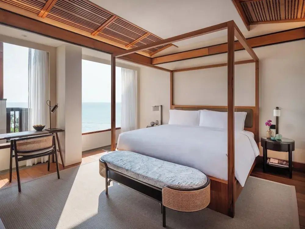 Helles Schlafzimmer mit Himmelbett und Meerblick