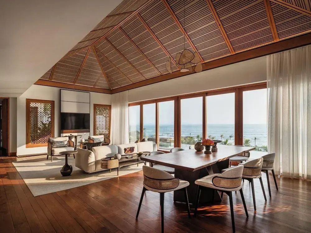 Großzügiger Wohnbereich mit Holzböden und Panoramafenstern mit Meerblick