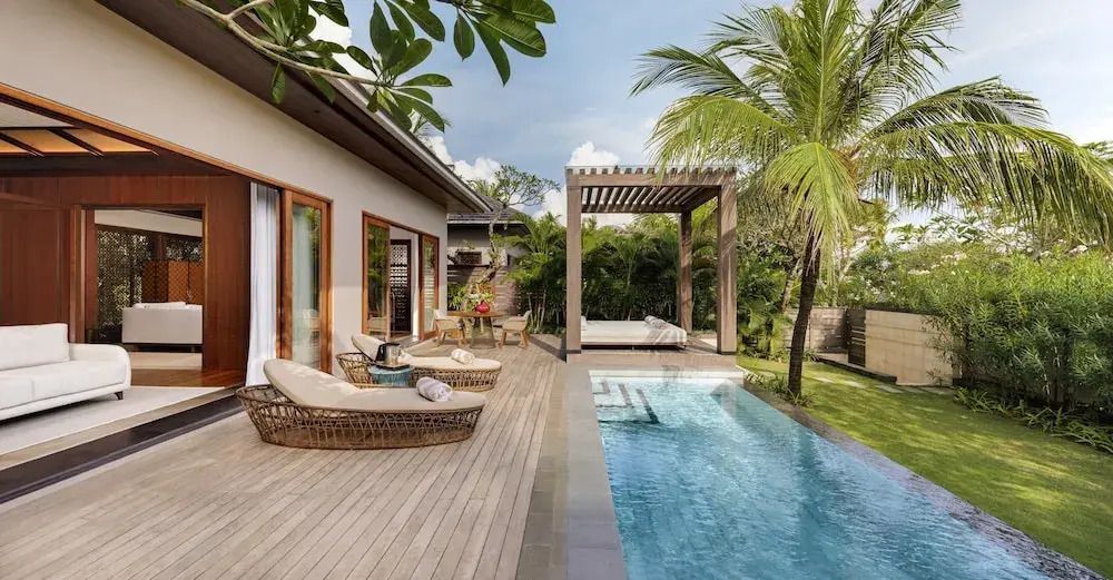 Privater Pool mit Liegestühlen und umgeben von üppigem Grün in der Villa.